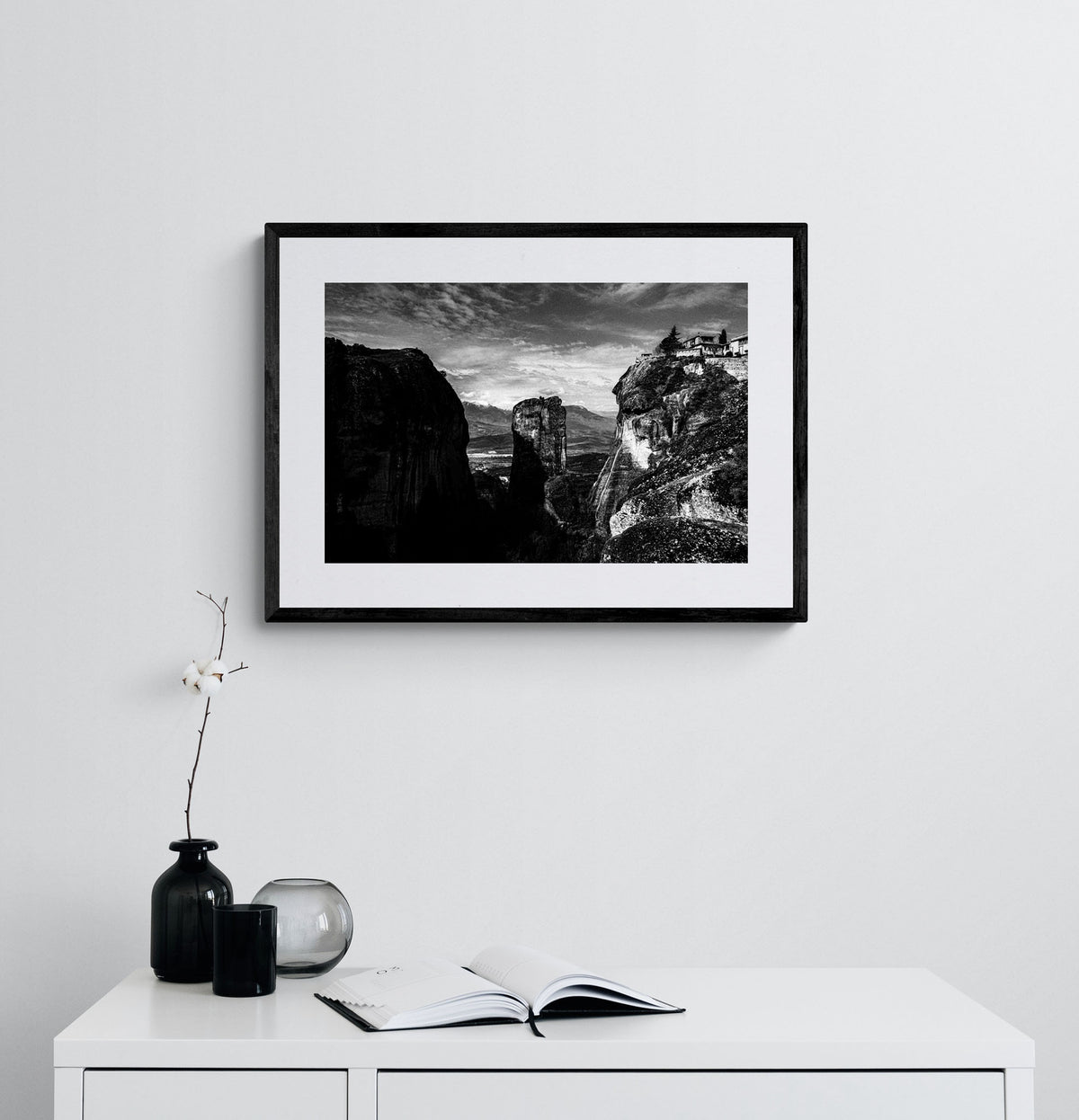 Rock pillars at Meteora. Black-and-white photography print by George Tatakis from the project Chorōs. Framed atwork on a white wall