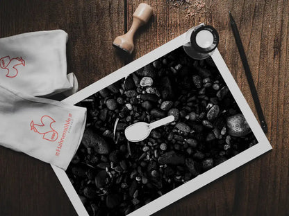 Black Pebbles and Shovel | Santorini | Chorōs | Black-and-white wall art photography from Greece - photo print on table