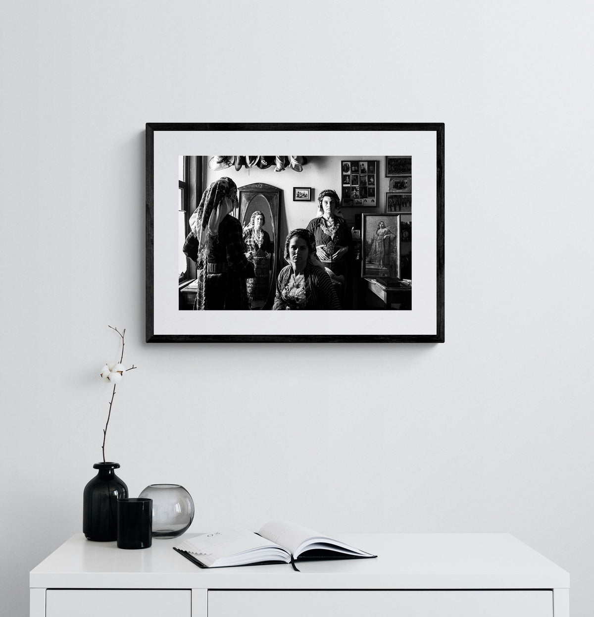 A group of women with a mirror wearing the local costumes of Soufli, Thrace, Greece. Black and white photography framed on a wall by George Tatakis.